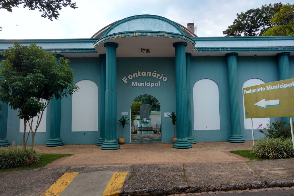 Fachada azul-turquesa do Fontanário Municipal de Águas de São Pedro, com colunas e arco de entrada