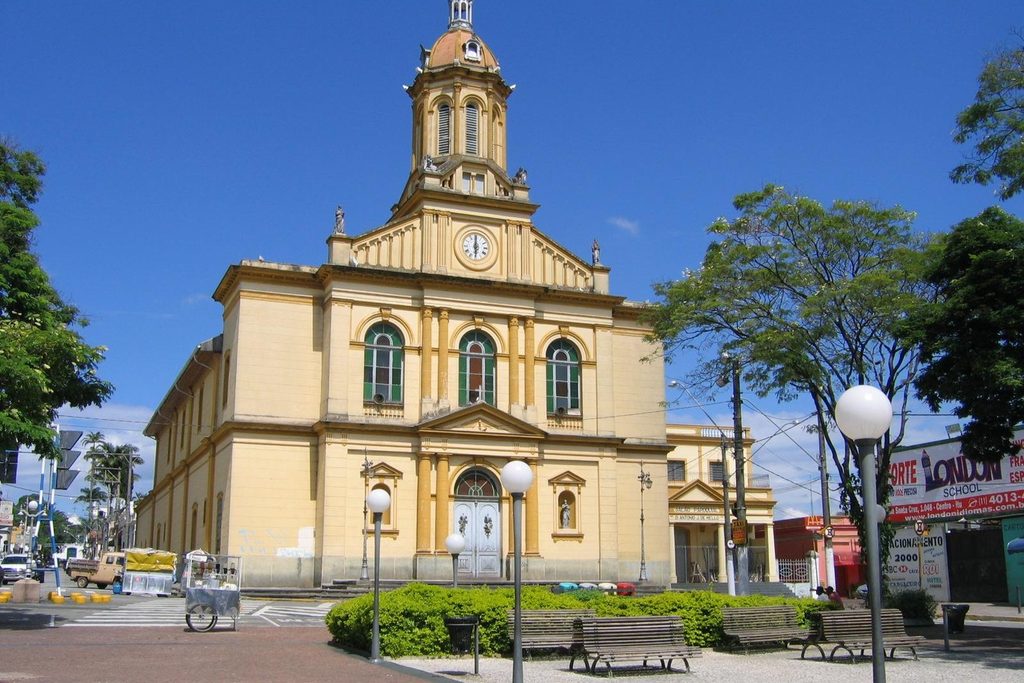 Igreja Matriz de Nossa Senhora da Candelária, de fachada amarela e branca com torre central e relógio, sob céu azul, em Itu