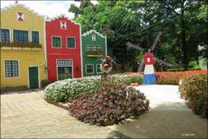 Casinhas coloridas em estilo holandês com moinho decorativo e jardim em Holambra, SP