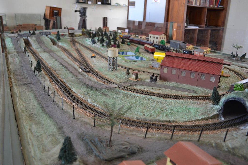 Maquete ferroviária com trilhos em curva, túnel, casinhas e estação em miniatura no museu da Estação de Jaguariúna