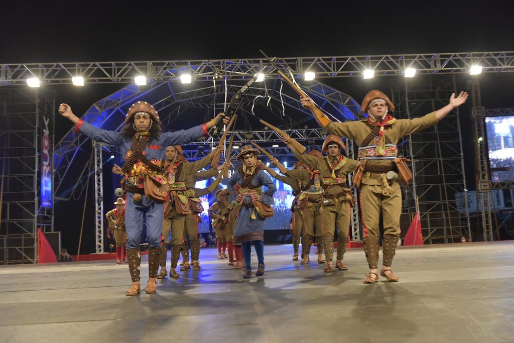 Grupo de dançarinos vestidos de cangaceiros apresentando o xaxado no Festival do Folclore de Olímpia, à noite
