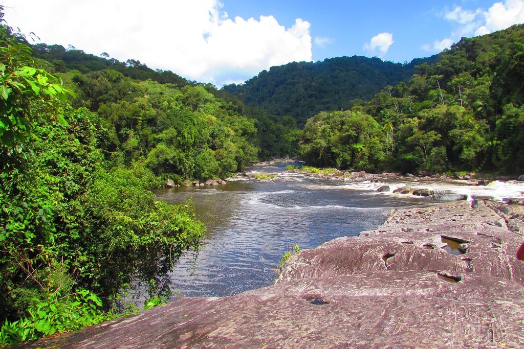 Rio largo correndo entre lajes de pedra e mata fechada no Salto Grande, no Núcleo Santa Virgínia