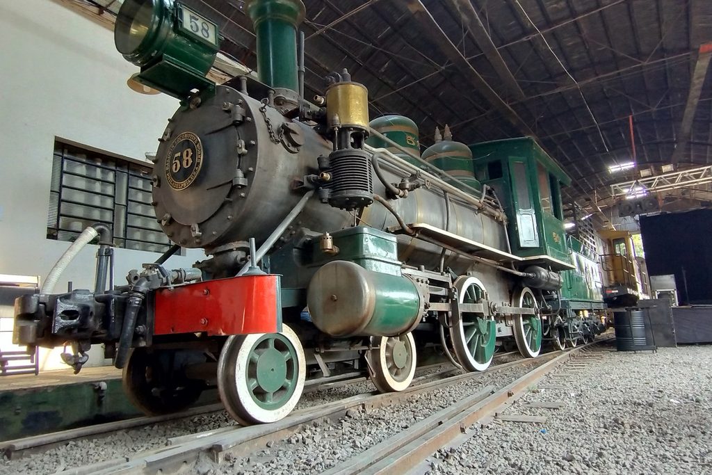 Locomotiva a vapor nº 58, de 1891, preta e verde, uma das que puxam o Trem dos Operários, dentro de um galpão ferroviário em Sorocaba