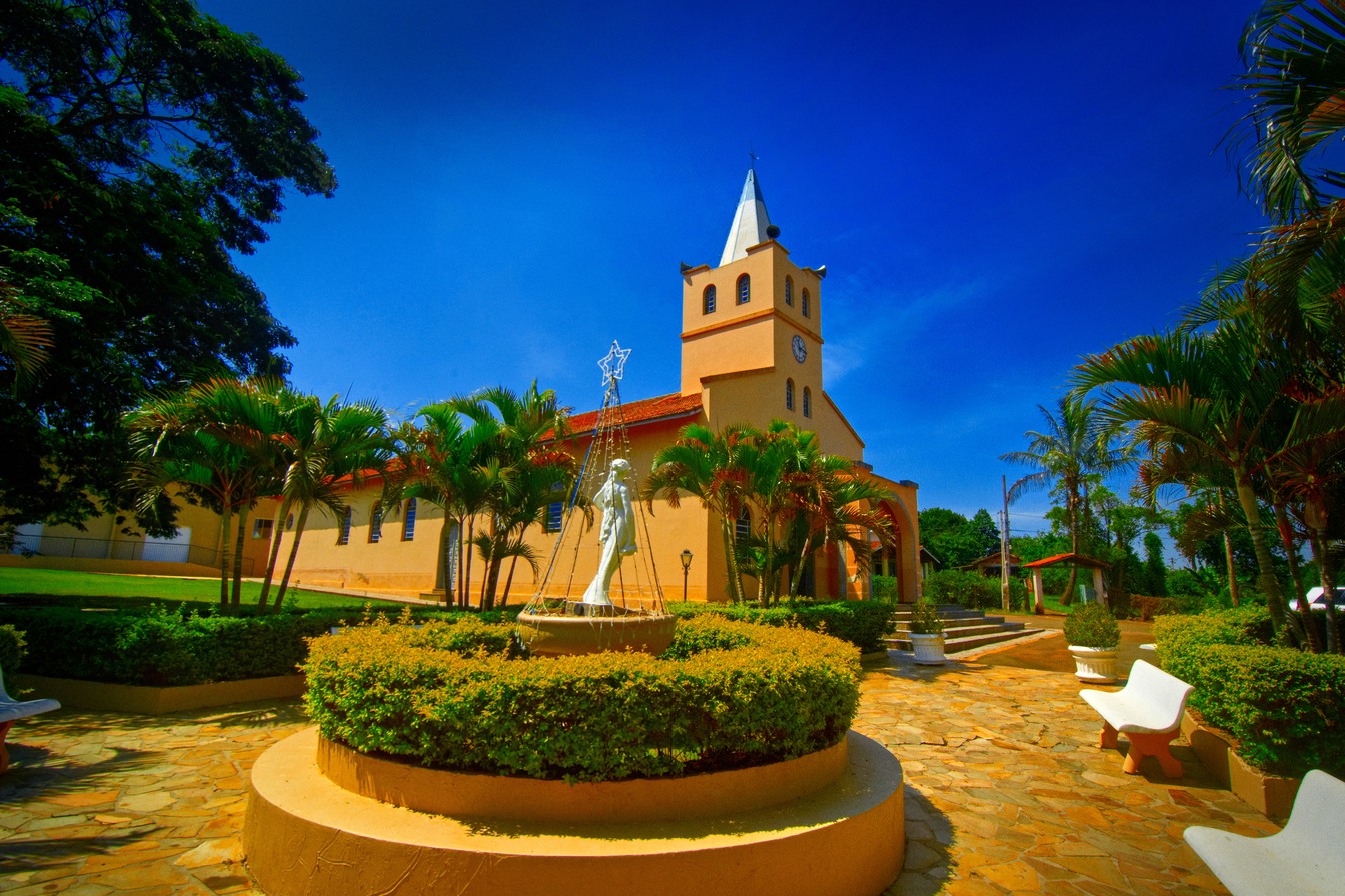 Igreja amarela de torre com relógio e praça com fonte, jardim circular e imagem branca de Nossa Senhora, o Santuário de Fátima de Tatuí