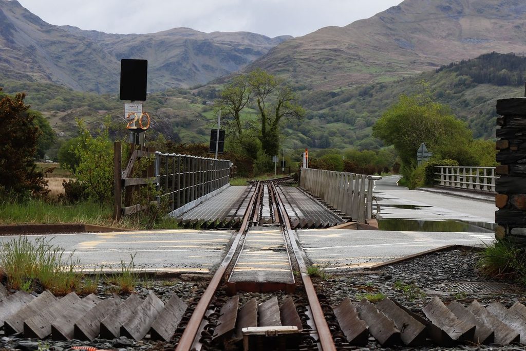 Cruzamento ferroviário tranquilo em paisagem rural de montanha
