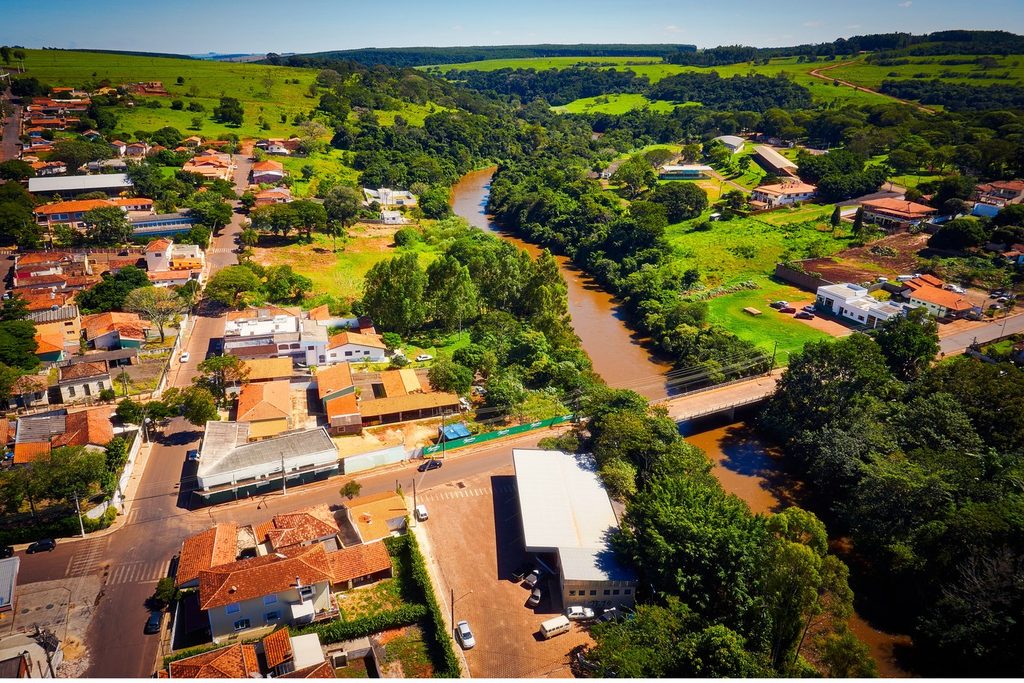 Vista aérea da cidade com o Rio Pardo passando entre casas, mata e uma ponte