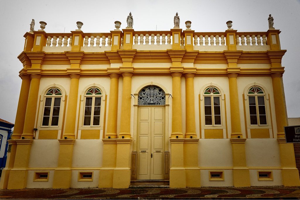 Casarão amarelo do Museu Bernardino de Campos, em Amparo, com colunas, janelas em arco, platibanda com balaústres e estátuas no alto