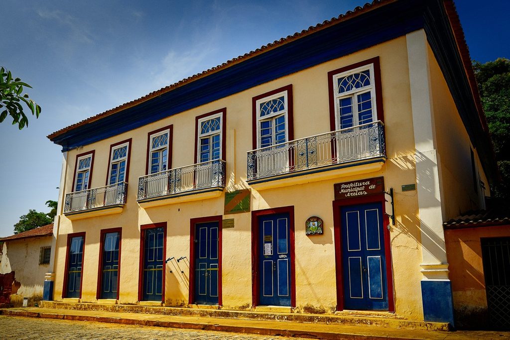 Casarão colonial amarelo de dois andares, com portas azuis, janelas vermelhas e sacadas de ferro, sede da Prefeitura de Areias