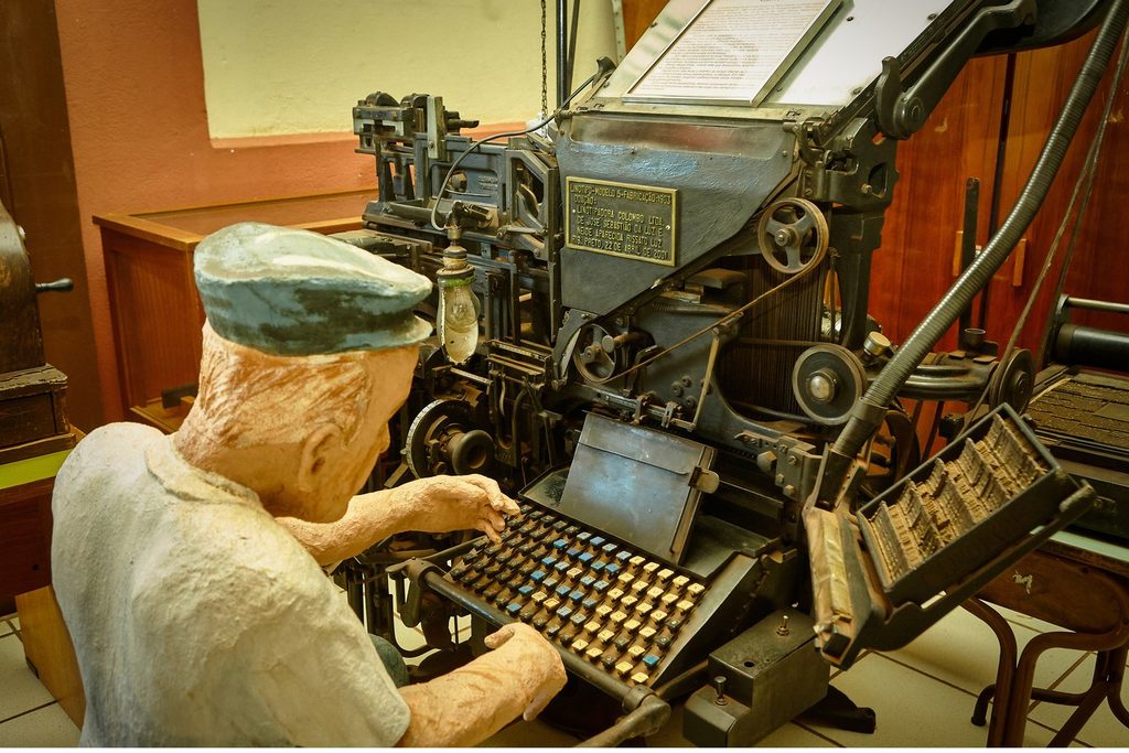 Antiga máquina de linotipo com boneco de tipógrafo exposta no museu da Estação da Cultura