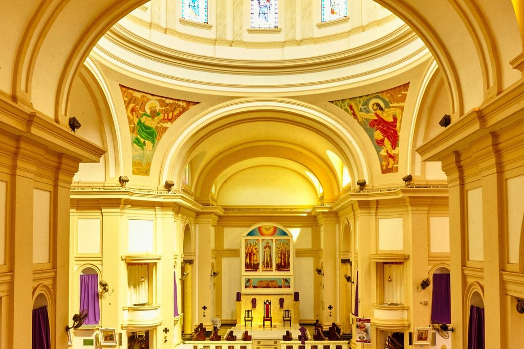 Nave da igreja matriz de Batatais com arcos, vitrais na cúpula e pinturas de Portinari no alto dos arcos e no altar