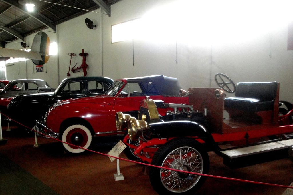 Carro Humber de 1909 com rodas raiadas no museu de Bebedouro, ao lado de um conversível vermelho