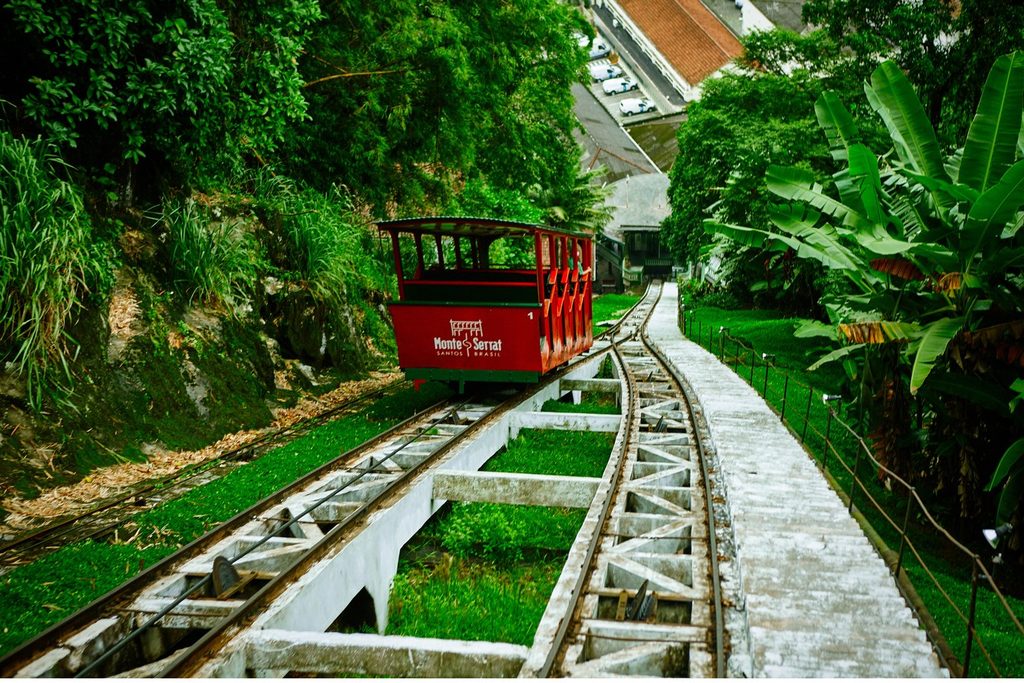 Vagão vermelho do funicular do Monte Serrat descendo os trilhos inclinados no meio da mata