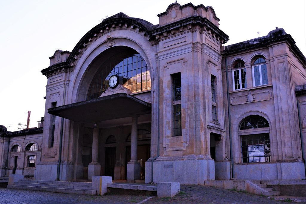 Fachada da antiga estação ferroviária de Botucatu, com grande arco envidraçado, relógio e colunas de pedra