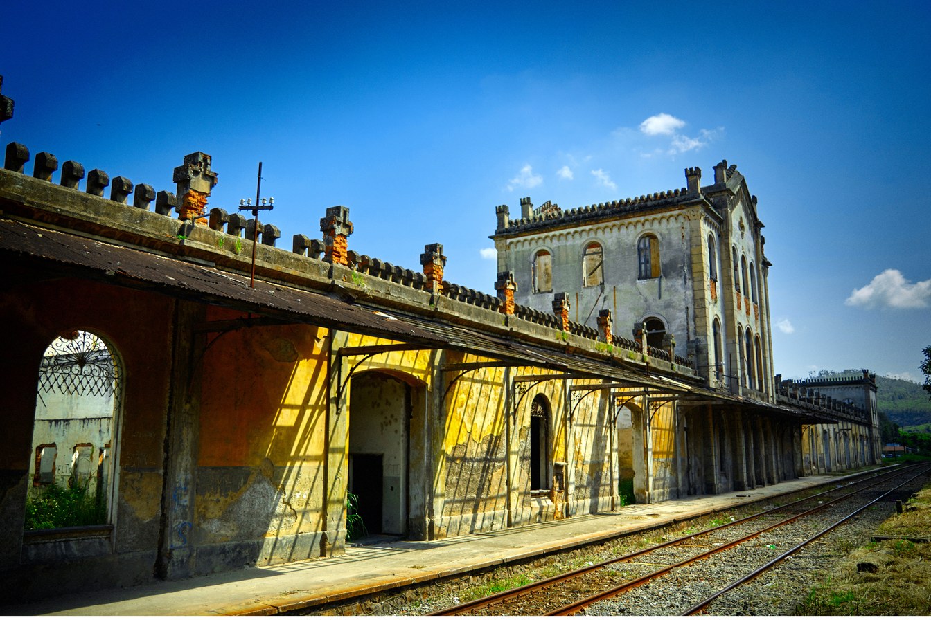 Plataforma da estação ferroviária de 1877 de Cachoeira Paulista, com arcos, platibanda ornamentada e trilhos