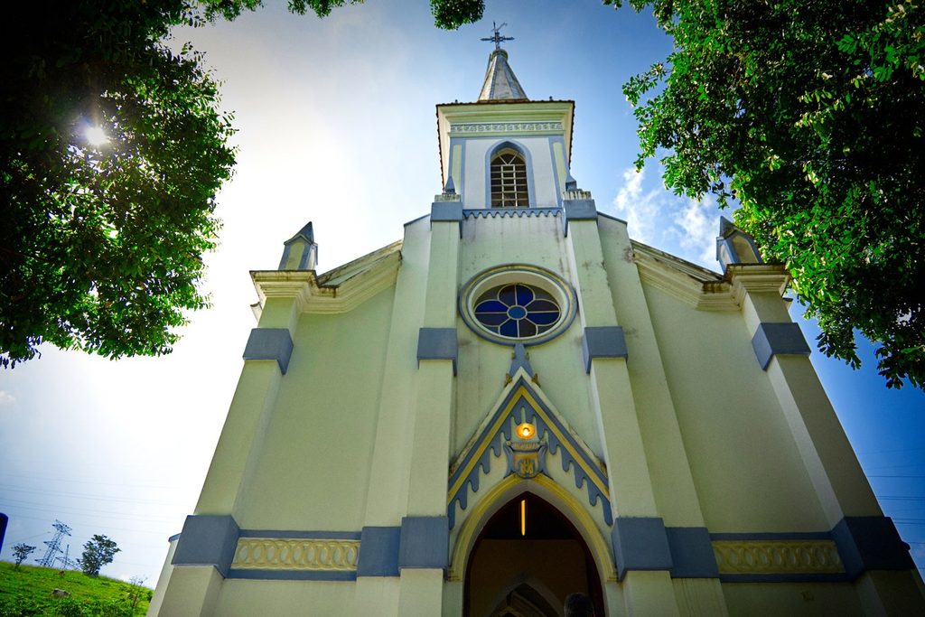 Fachada neogótica creme e azul do Santuário Nacional de Santa Cabeça, com rosácea e torre