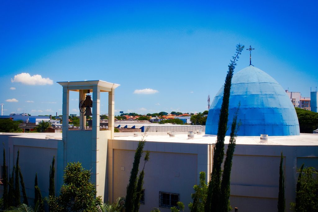 Santuário de Nossa Senhora Desatadora dos Nós, em Campinas, com cúpula azul e torre branca com sino entre ciprestes