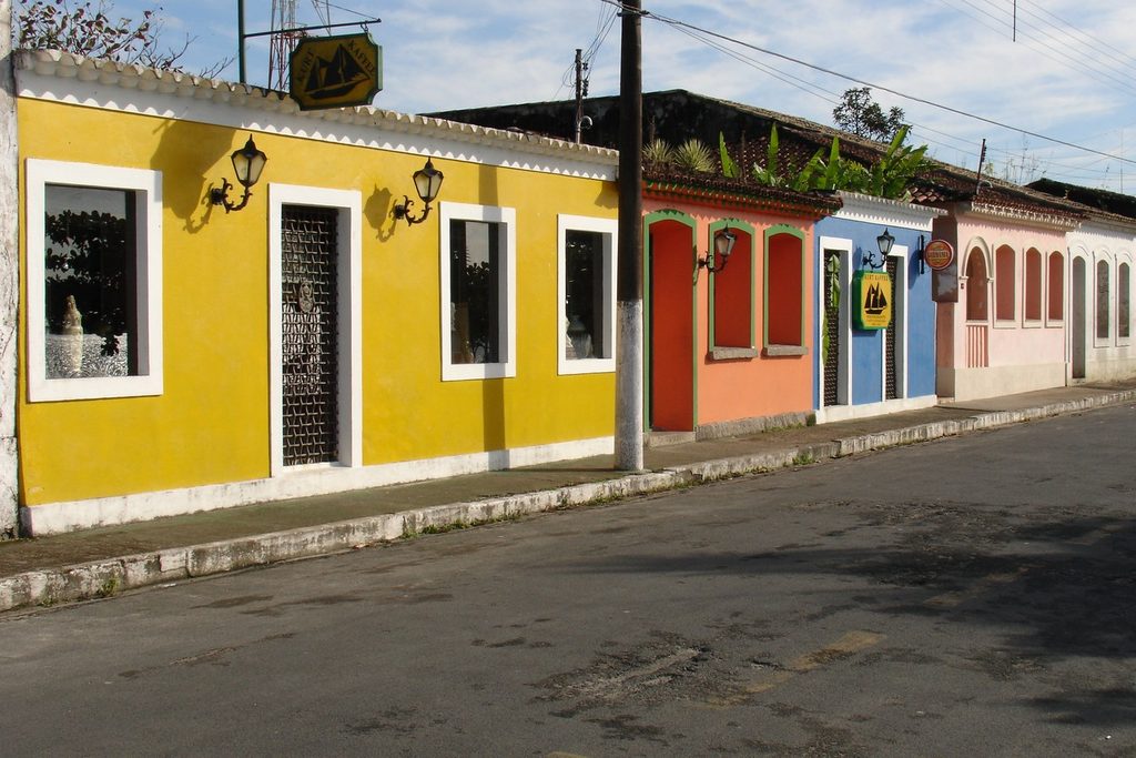 Casas coloridas lado a lado, amarela, vermelha, azul e rosa, numa rua do centro histórico de Cananéia