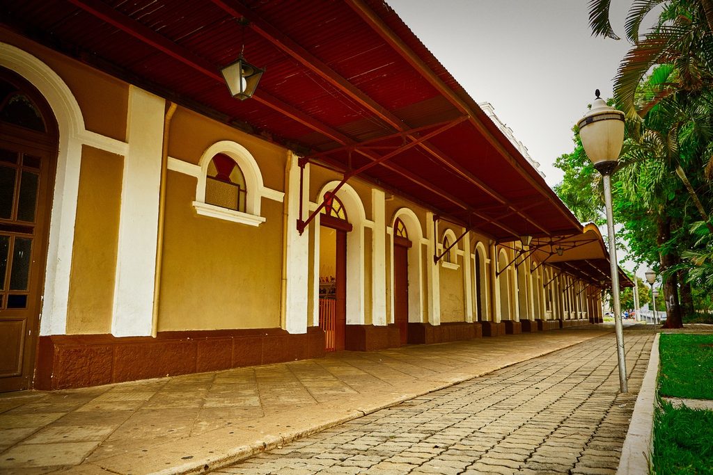Plataforma da antiga estação da Mogiana, com arcos amarelos, portas de madeira e cobertura de madeira apoiada em mãos-francesas