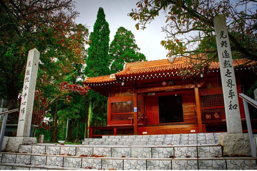 Templo de madeira vermelha em estilo japonês na Academia da Seicho-No-Ie, em Ibiúna, com colunas de pedra com inscrições e árvores em volta