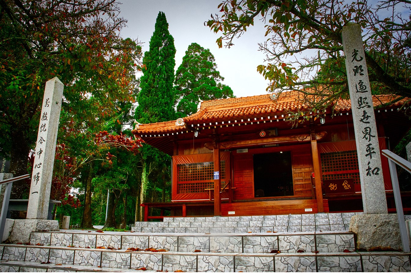 Templo de madeira vermelha em estilo japonês na Academia da Seicho-No-Ie, em Ibiúna, com colunas de pedra com inscrições e árvores em volta