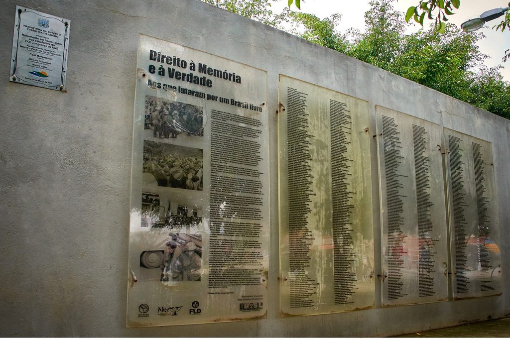 Monumento à Memória Estudantil em Ibiúna, muro com painéis de vidro com nomes e fotos dos estudantes de 1968