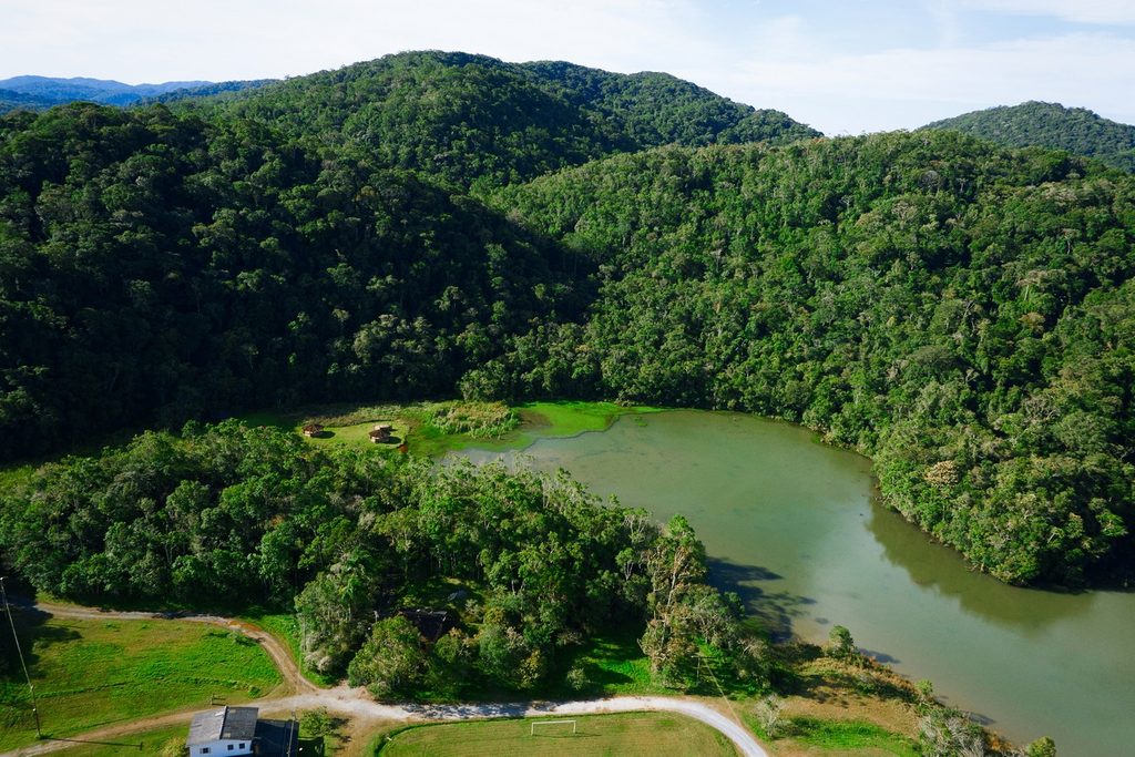 Vista do alto de um lago cercado por morros cobertos de mata fechada no Parque Estadual Intervales