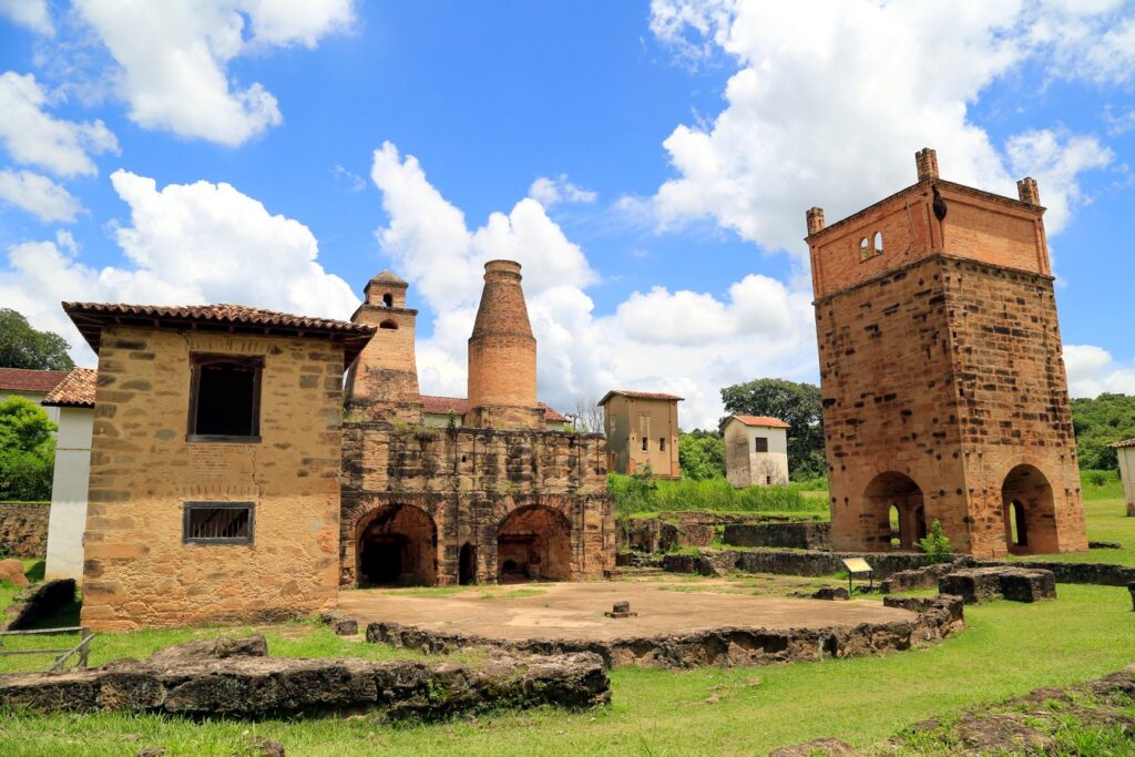 Ruínas dos altos-fornos de pedra e tijolo da Real Fábrica de Ferro na Fazenda Ipanema, com torre quadrada e chaminé, sob céu azul