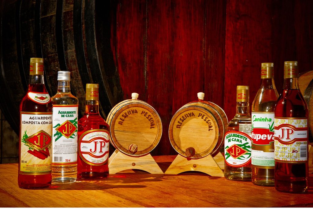 Garrafas de cachaça e aguardente da Caninha JP e barris de madeira de reserva pessoal