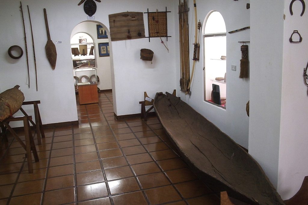 Sala do Museu Histórico de Jaboticabal com uma canoa indígena de madeira no chão e objetos antigos nas paredes