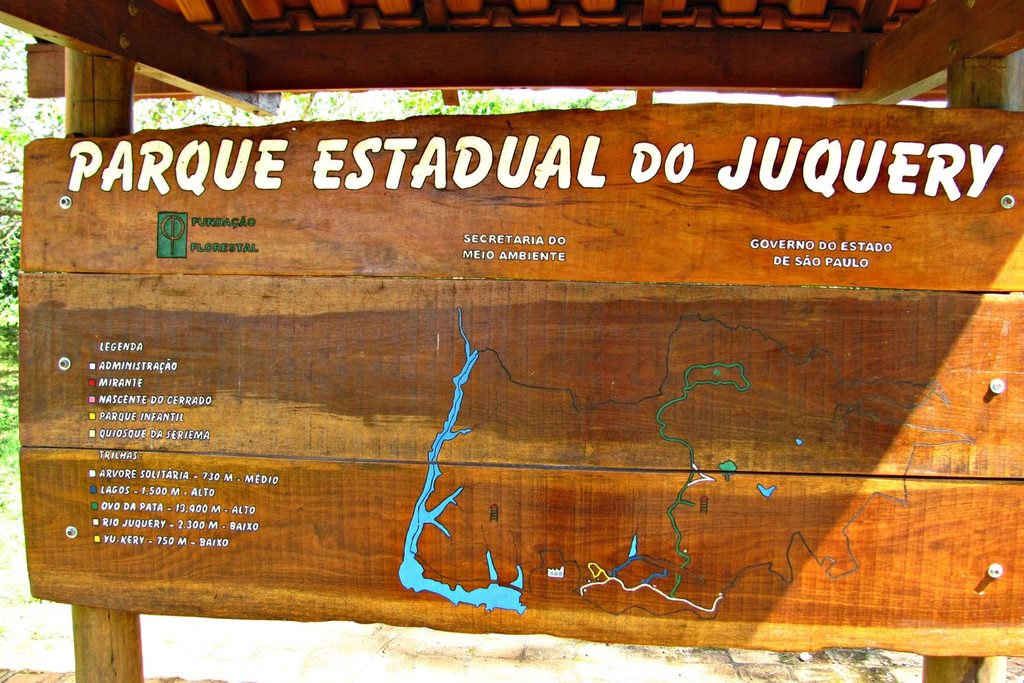 Placa de madeira com o mapa das trilhas e dos lagos do parque, na entrada