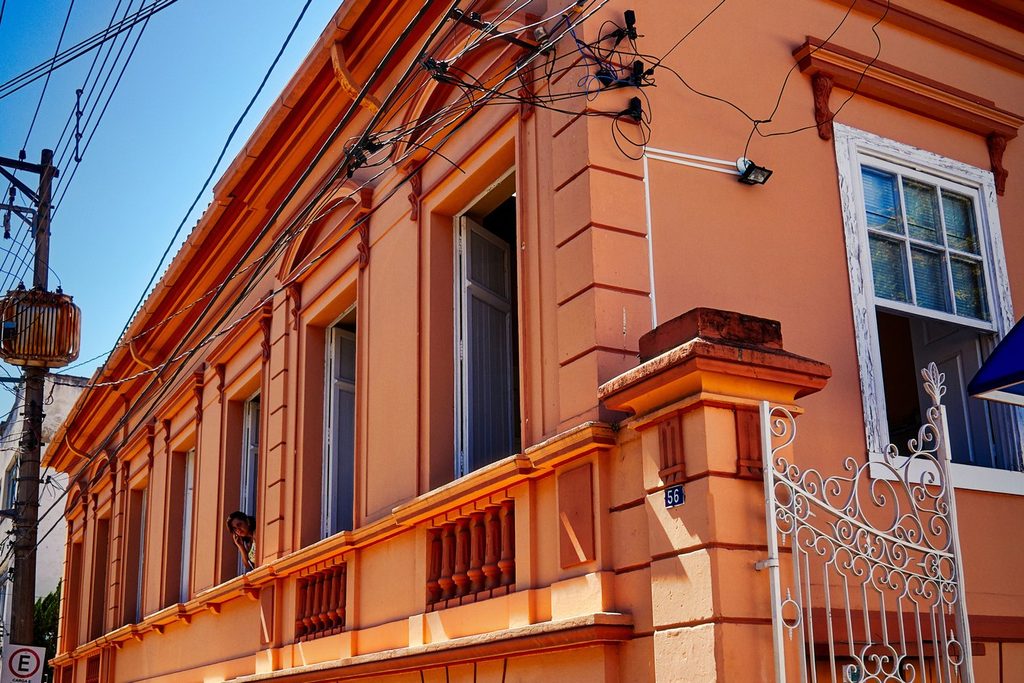 Fachada salmão do Solar dos Azevedos, em Lorena, com janelas altas e portão de ferro