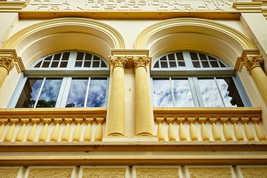 Fachada amarela da Casa de Cultura Rogério Cardoso, com janelas em arco, colunas e a inscrição da antiga escola profissional