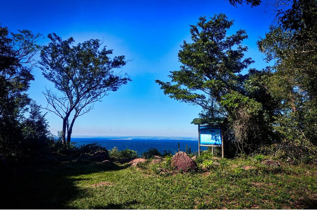 Mirante em meio à mata no Morro do Diabo, com placa de informação e o horizonte ao fundo