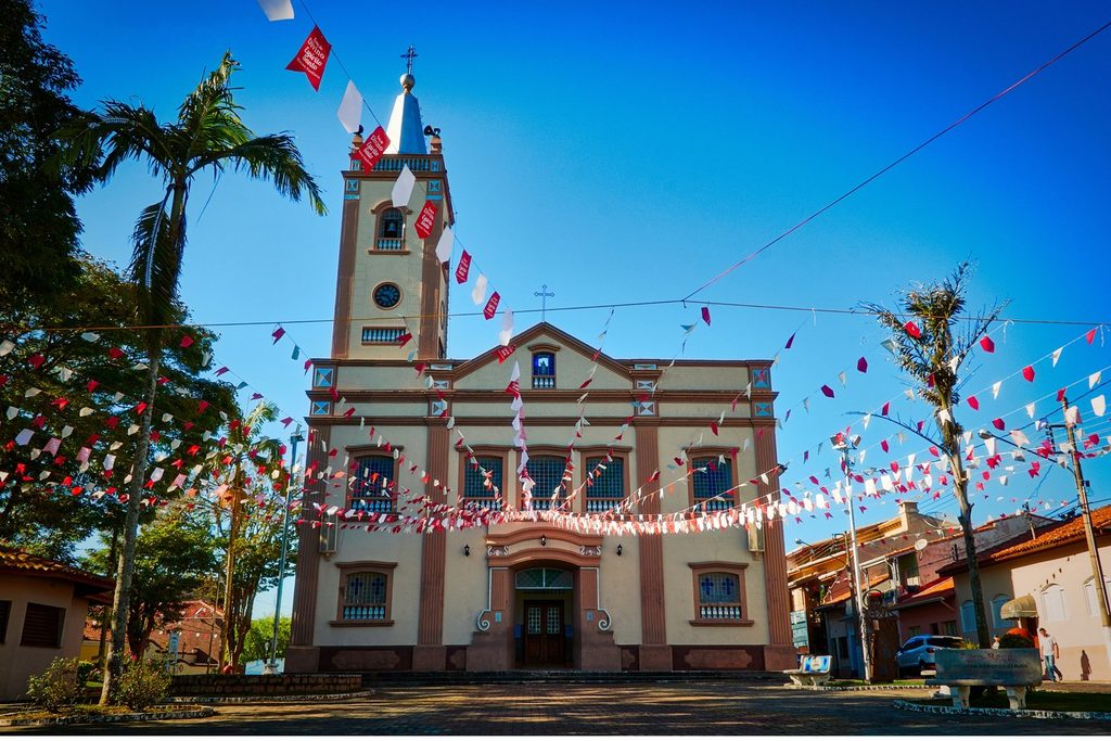 Fachada da Igreja Matriz de Nossa Senhora de Nazaré, em Nazaré Paulista, com torre e bandeirinhas de festa