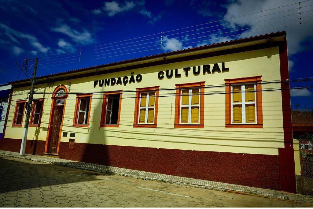 Casarão térreo amarelo e vinho com janelas de madeira e o letreiro Fundação Cultural na fachada