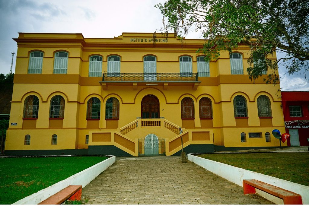 Prédio amarelo de dois andares do Instituto Santo Antônio, com escadaria dupla e janelas em arco
