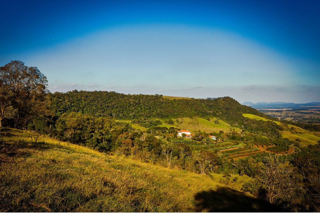 Morros verdes da Cuesta vistos do mirante da Fazenda São Pedro, com a sede da fazenda ao fundo