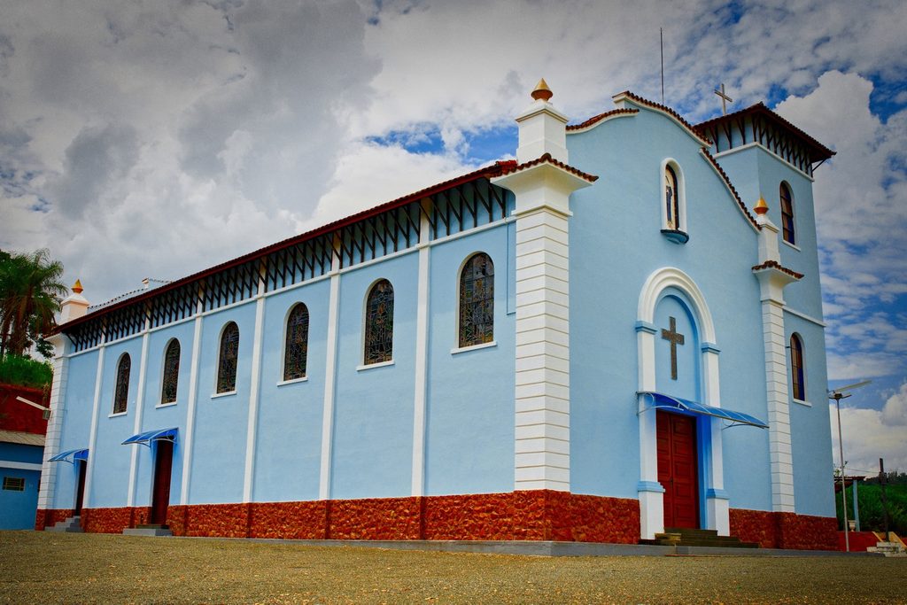Igreja azul-clara com detalhes brancos, torre baixa e janelas em arco, a Igreja de Santa Rita de Cássia