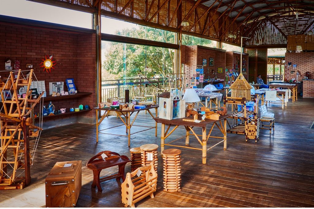 Salão da Casa do Artesão com peças de madeira, brinquedos e artesanato expostos em mesas