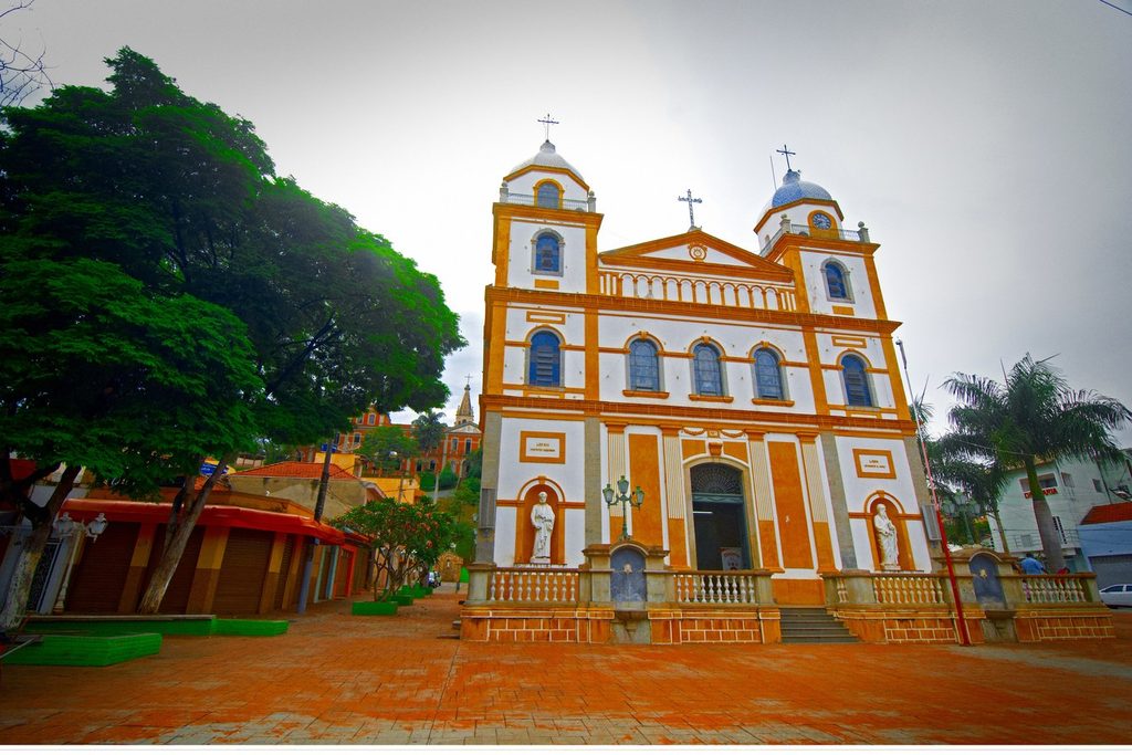 Fachada amarela e branca do Santuário do Senhor Bom Jesus de Pirapora, com duas torres e estátuas na entrada