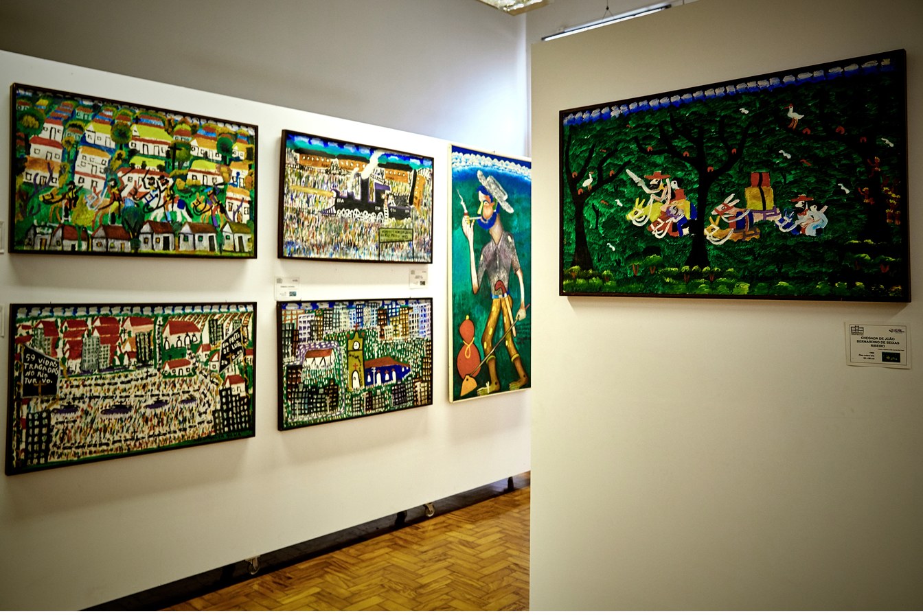 Telas coloridas de arte primitivista penduradas na parede do Museu de Arte Primitivista, em São José do Rio Preto