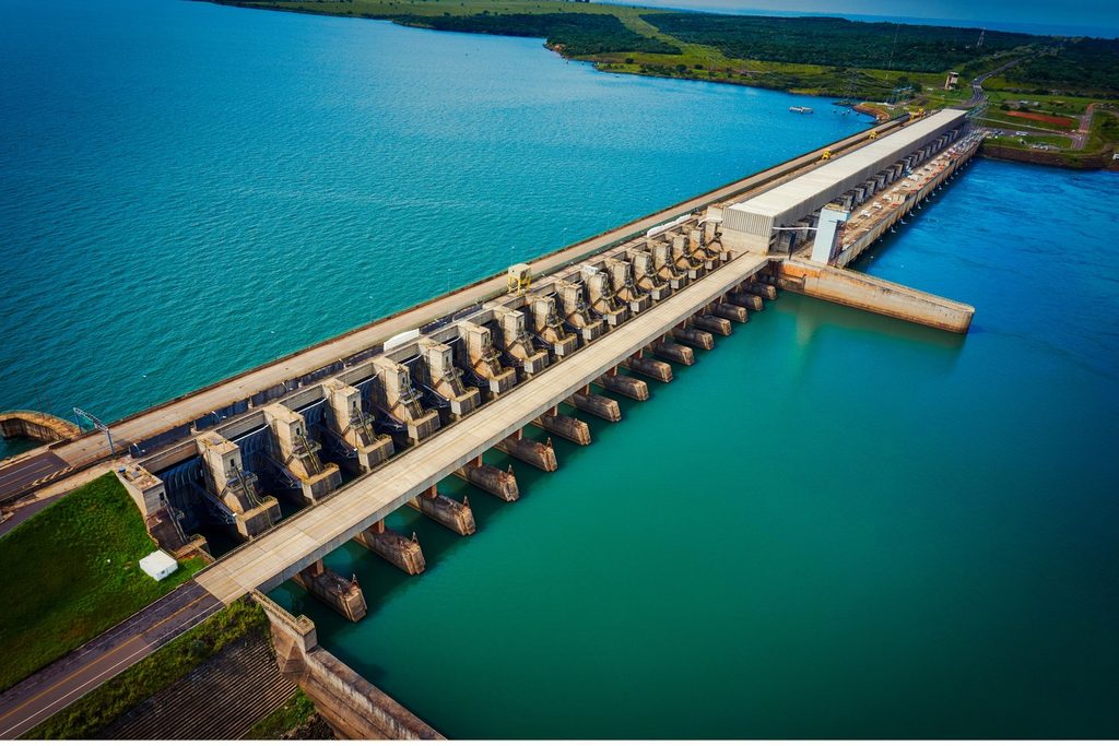 Vista aérea da barragem da usina hidrelétrica Engenheiro Sérgio Motta, com a água azul e verde do reservatório