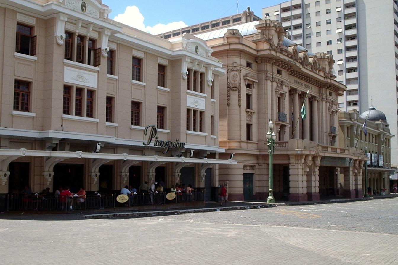 Prédios históricos do Quarteirão Paulista, em Ribeirão Preto, com a Choperia Pinguim e mesas na calçada e, ao lado, a fachada ornamentada do Theatro Pedro II
