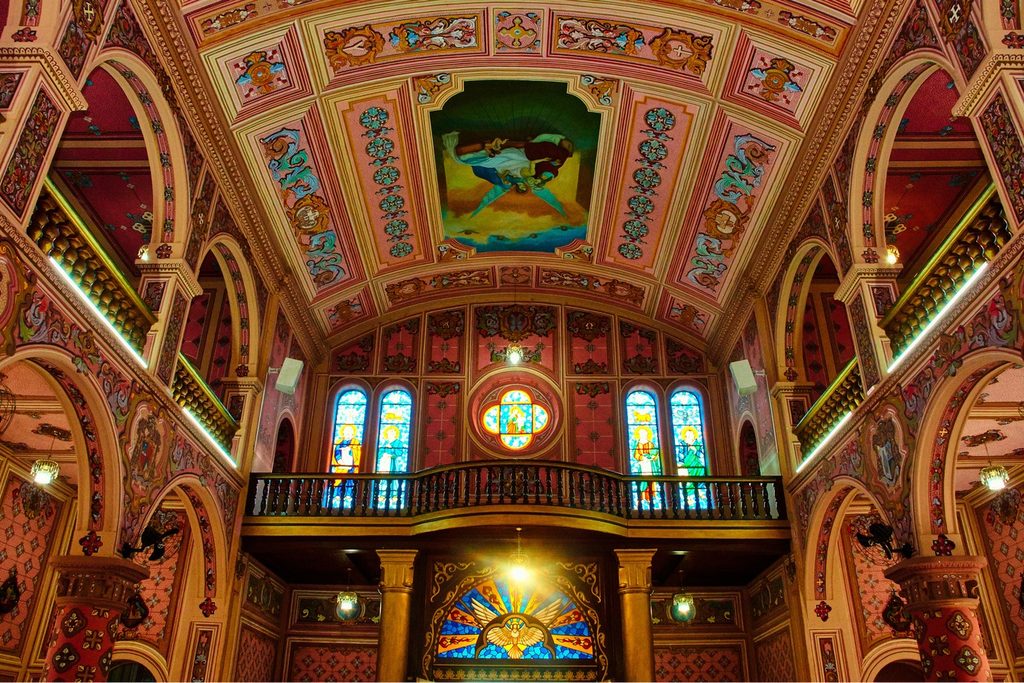 Interior da Igreja Matriz de São José com teto em abóbada todo pintado, arcos coloridos e vitrais