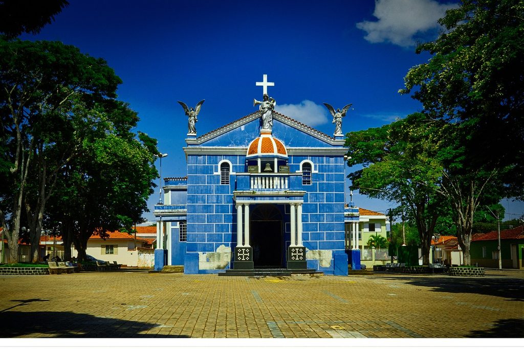 Igreja de Nossa Senhora do Rosário, azul com detalhes brancos e anjos no alto, na praça de Santo Antônio da Alegria
