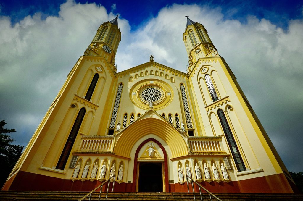 Fachada neogótica amarela da Igreja Matriz de São José, em São José do Rio Pardo, com duas torres pontiagudas e rosácea