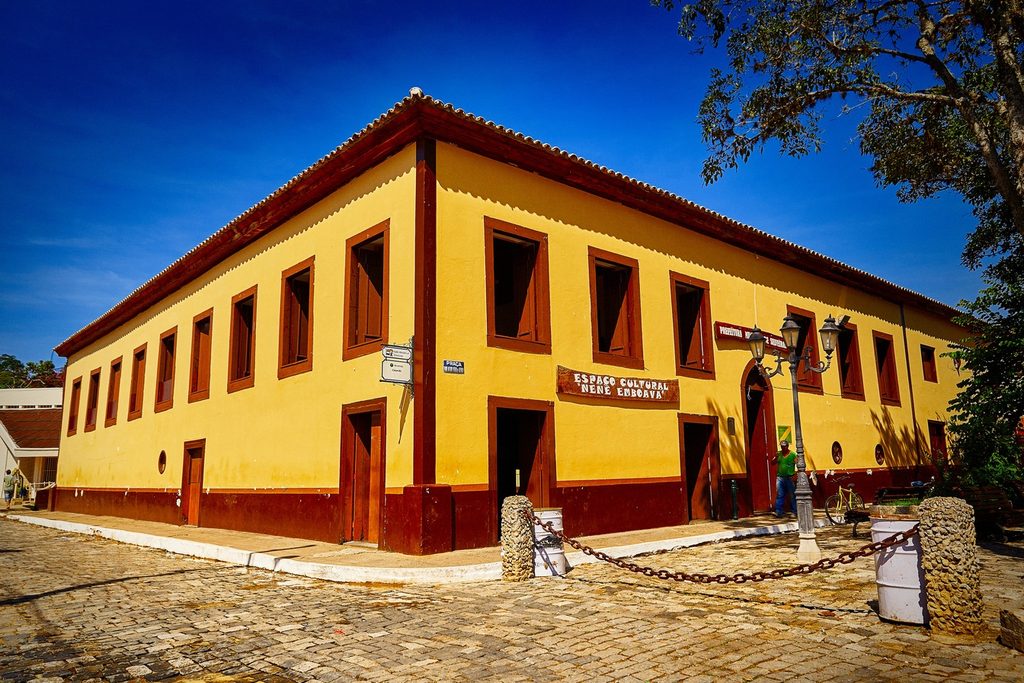 Casarão amarelo de dois andares com janelas e portas vermelhas, sede do Espaço Cultural Nenê Emboava, em Silveiras