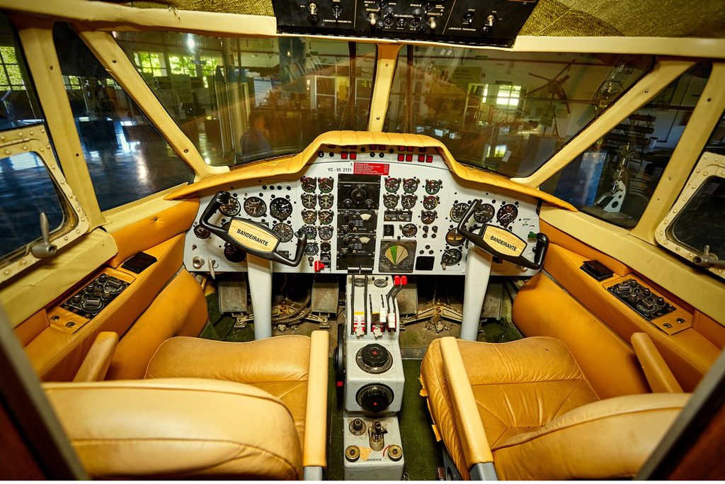 Cabine de comando de avião antigo, com bancos de couro e painel de instrumentos, no Memorial Aeroespacial Brasileiro