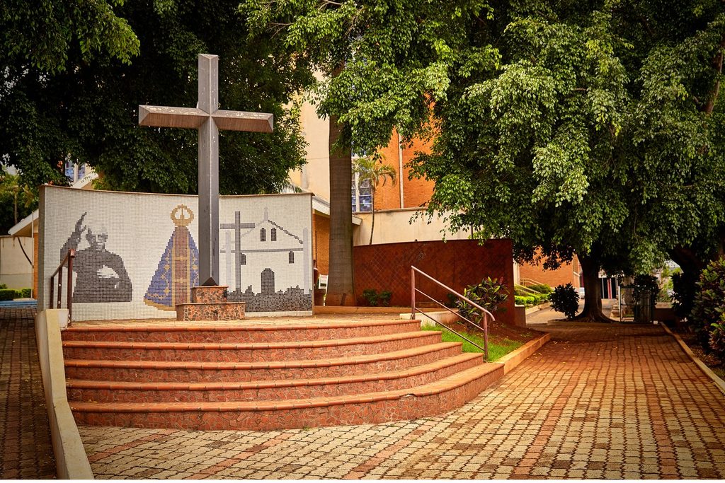 Cruzeiro e painel em mosaico com o Padre Donizetti, Nossa Senhora Aparecida e a antiga igreja, na praça de Tambaú