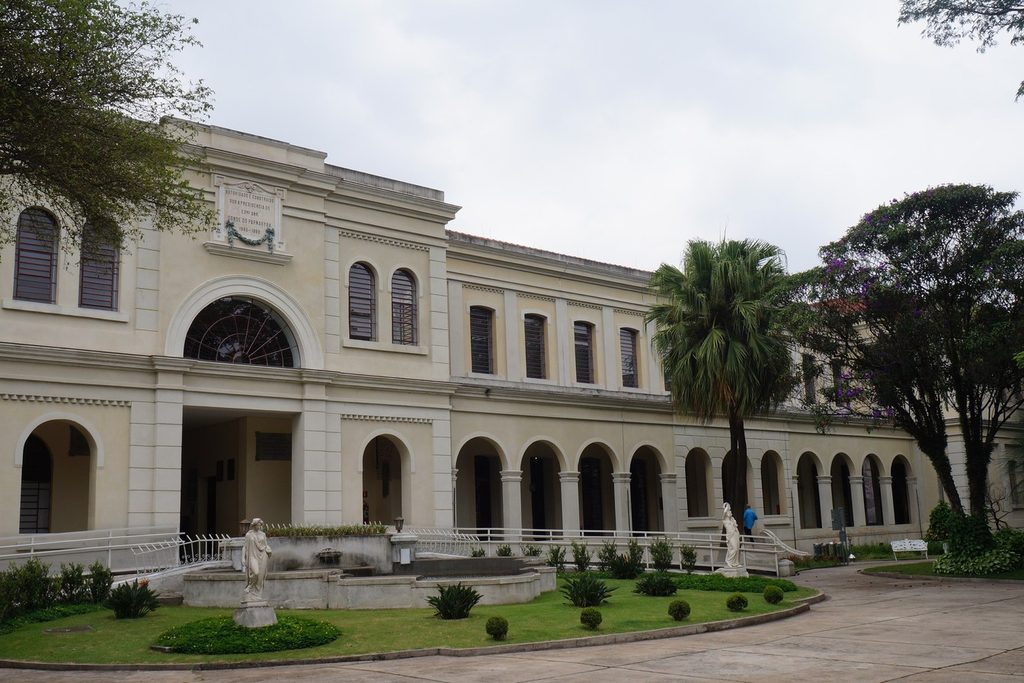 Fachada do Museu da Imigração, ponto de partida da Maria Fumaça da Mooca, com arcos, jardim e palmeiras